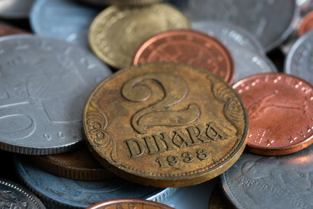 Two dinar coin from Kingdom of Yugoslavia close up, lying on a pile of various coins, uncirculated coin with corrosion and scratchesの写真素材