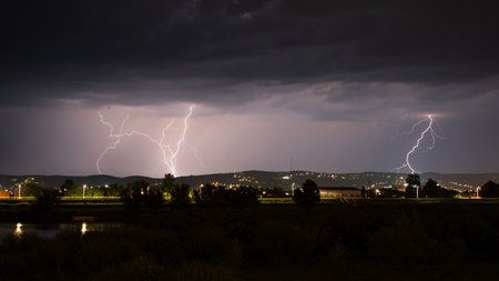 Multiple lightning during thunderstorm at night, over hills near croatian city of Slavonski Brod