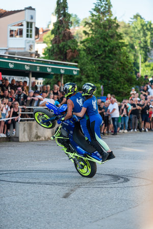 Moto tandem stunt ride show on street, freestyle stunt show in front of audienceのeditorial素材