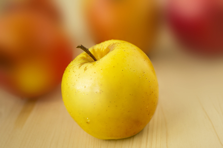 Yellow apple on wood and blur backgroundの写真素材