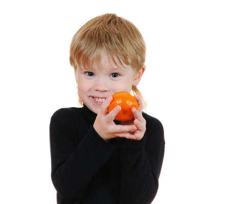 The cheerful child with orange isolated on white backgroundの写真素材