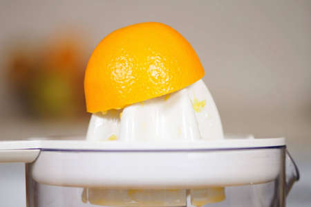 Squeezing of orange juice on a juice extractorの写真素材