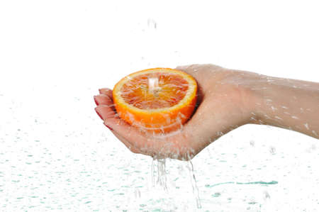 To wash a red orange under water isolated on white backgroundの写真素材