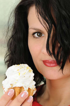 The beautiful woman eats a cake is shoot close upの写真素材