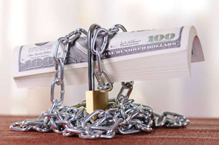 Dollars are closed on the padlock and a chainの写真素材