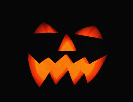  pumpkin with lighting candle inside on black backgroundの写真素材
