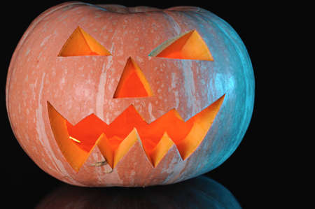  pumpkin with lighting candle inside on black backgroundの写真素材