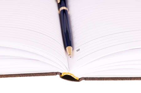 brown business diary with pen isolated on white backgroundの写真素材