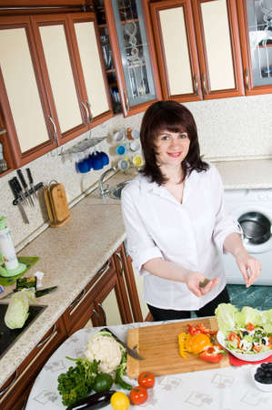 beautiful woman prepares food in the kitchenの写真素材