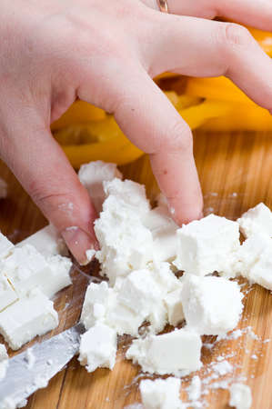 Preparation of salad from cheese and fresh vegetablesの写真素材