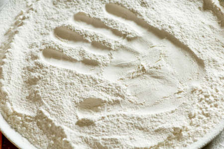 imprint of a woman's hand in a bowl with the flourの写真素材