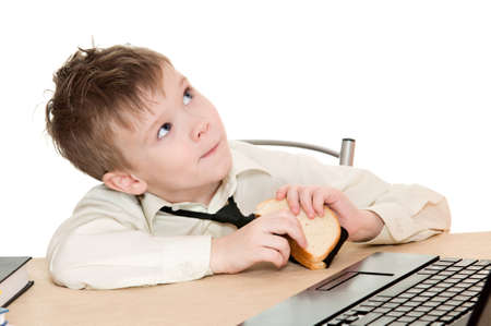 thoughtful boy eating a sandwich with his tie isolated on white backgroundの写真素材