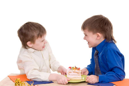 Two boys share a piece of cake on white backgroundの写真素材