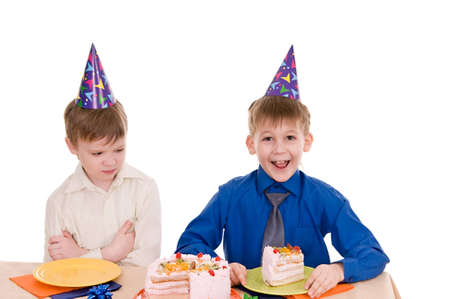 two boys eating a cake isolated on white backgroundの写真素材
