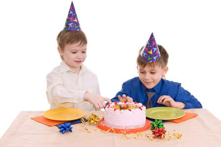 two boys eating a cake isolated on white backgroundの写真素材
