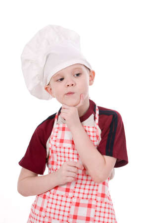 a pensive child chef isolated on white backgroundの写真素材