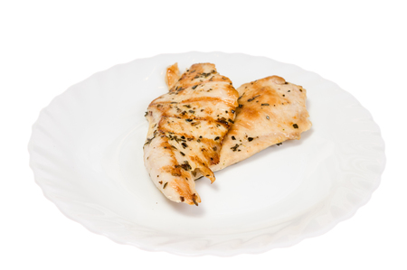 grilled chicken fillet on a white plate isolated white backgroundの写真素材