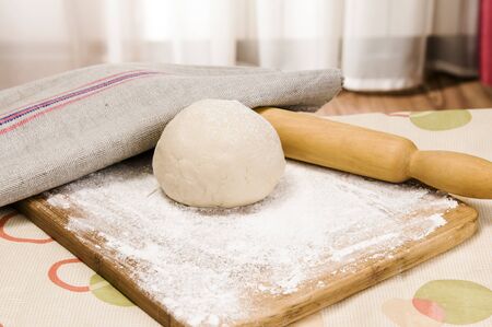 fresh raw dough and rolling pin for bakingの写真素材