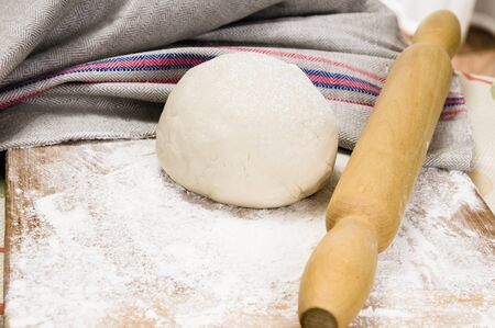 fresh raw dough and rolling pin for bakingの写真素材