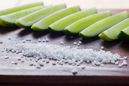 The cut cucumber on a board with sea salt.の写真素材