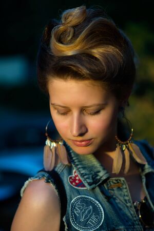 Beautiful woman outdoors enjoying summer sun. Wearing jeans jacket. Relaxing and calm.の写真素材