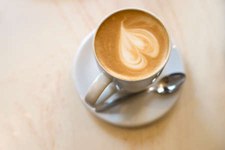 Extra large cappuccino cup with spoon on the brown wooden tableの写真素材