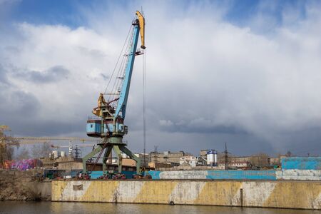 Two old crane loading cargo in the river port, moscow river