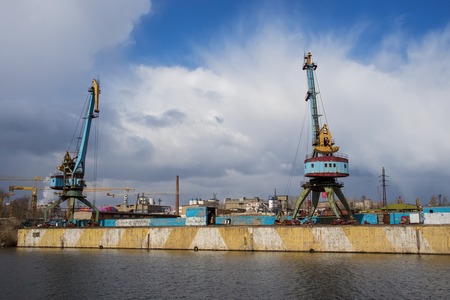 Two old crane loading cargo in the river port, moscow riverの写真素材