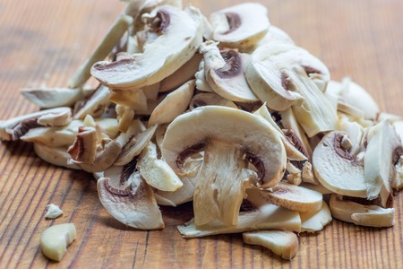 Fresh sliced champignon mushrooms on a wooden deckの写真素材