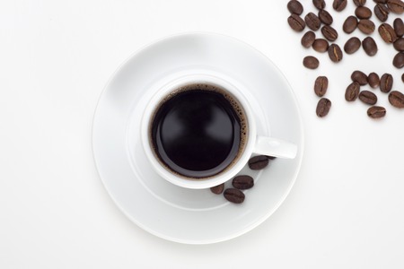 Black coffee with bubbles in white cup with coffee beans, view from above.の写真素材