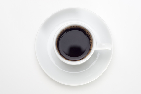 Black coffee with bubbles in white cup with coffee beans, view from above.の写真素材