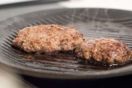 Two Fresh meat cutlets in a frying pan grill.の写真素材