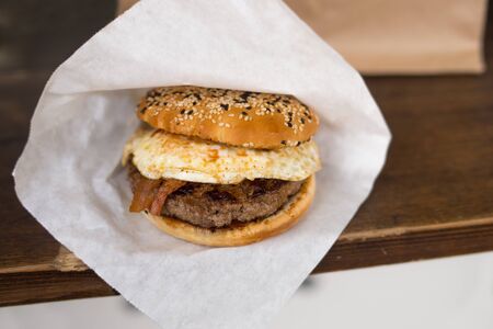 Tasty hamburger with fast food in a white paper on the wooden table.の写真素材