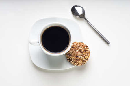 Cup of hot coffee with cookies and a spoon on white backgroundの写真素材