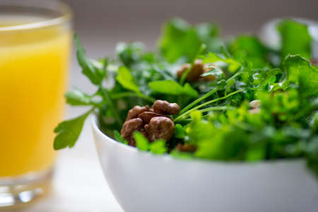 Green salad with arugula salad on rustic wooden background and glass of Orange juice.の写真素材