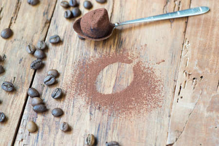 Dark chocolate truffles with cocoa powder, coconut and chopped hazelnuts on a wooden table.