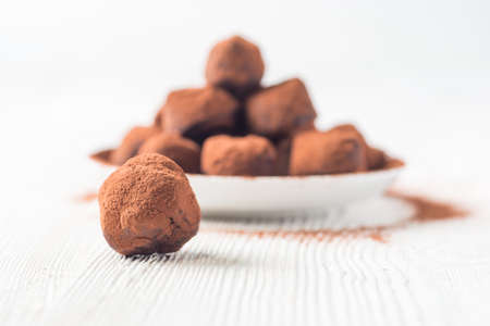 Homemade healthy vegan chocolate truffles, coconut flakes and rolled oats served on white plateの写真素材