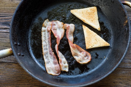 Frying bacon and toast  in the pan.の写真素材