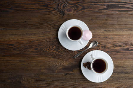 Coffee cups on rustic wooden table with marshmallow and anice. Percent sign made of coffeeの写真素材