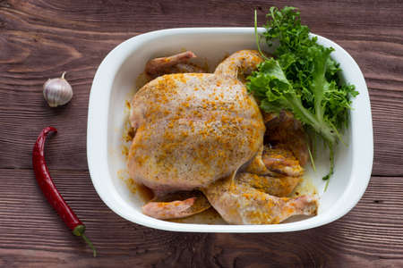 Whole Roasted chicken in gratin dish with garlic, salad and pepper. Top viewの写真素材