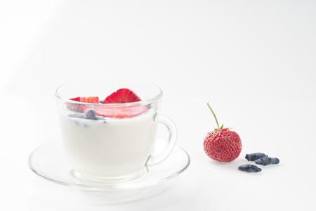 Milk fruit dessert. Serving tasty treats from dairy cream and red strawberries standing on the wooden table.の写真素材