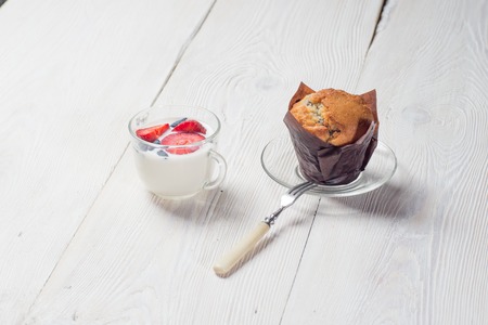 Strawberry milkshake with delicious muffin on white wooden backgroundの写真素材