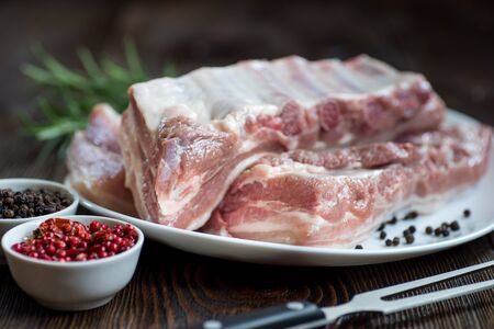 Raw pork belly with salt, pepper, chili, rosemarry,  rustic style.の写真素材