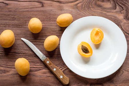 Cuted  apricots with leaves on wooden background.の写真素材