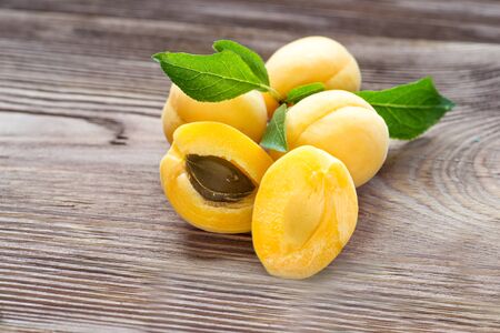 Apricots on a dark wood background. toning. selective focus on apricots with a stone.の写真素材