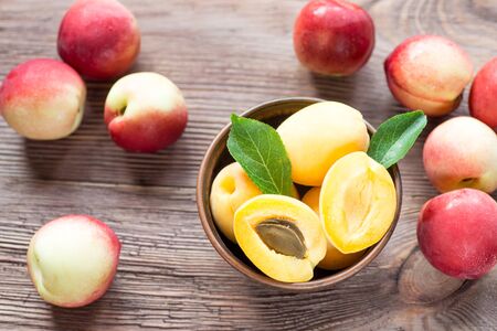 Nectarines, Peach and apricots in a bowl on wooden tableの写真素材