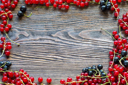 Berries on Wooden Background. Summer or Spring Organic Berry over Wood. Red and black currant....