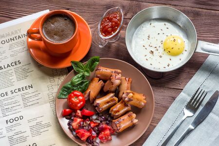 Traditional breakfast - fried eggs, sausages, tomato, beans,  onions, Basil. Selective focusの写真素材