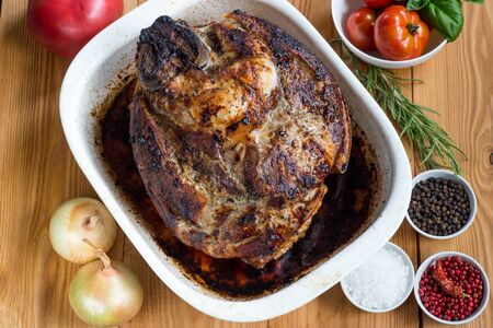 Gammon with a tomato, garlic, onions and herbs close up on a dark wood backgroundの写真素材