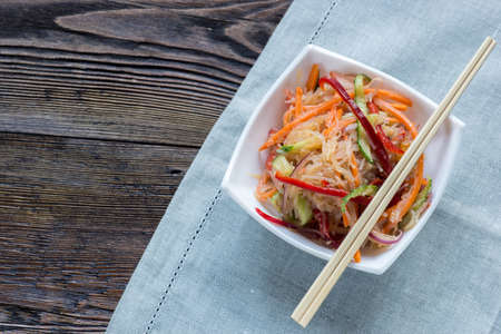 High view on elegant plate with rise noodles and vegetables with wooden sticks.の写真素材